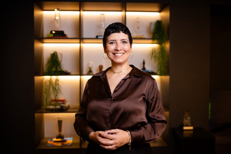 *por Juliana Maria - head de Produtos HCM na Senior Sistemas Existe uma força de trabalho em transformação, e as habilidades necessárias para atuar em um mundo permeado por IA ainda estão sendo construídas — muitas delas nem sequer possuem nome ou classificação formal em códigos ocupacionais. Apesar da velocidade de adoção, existe uma contradição: o volume de investimento em IA nas empresas é desproporcional aos resultados efetivamente colhidos. Parte do problema está em tentar aplicar IA a processos que já não fazem mais sentido, em vez de repensar os fluxos de trabalho antes de automatizá-los. 88% das organizações usam IA em ao menos uma função, mas apenas 39% reportam qualquer impacto no EBIT — e a McKinsey estima que ~75% dos cargos precisam de reformulação fundamental. A adoção aconteceu; o redesenho do trabalho, não. (dessa forma fica mais preciso) Em um cenário de transformações intensas, as skills humanas valem cada vez mais e abre-se uma janela de oportunidade para o desenvolvimento de times. De acordo com o World Economic Forum, 170 milhões de empregos serão criados até 2030, e 39% das habilidades essenciais exigidas mudarão até 2039. Cinco habilidades essenciais Mas quais, de fato, devem ser desenvolvidas? A partir de um grande debate com IAs e ouvindo a realidade de centenas de gestores de RHs, mapeei cinco que considero mais importantes para qualquer função que envolva o uso de inteligência artificial — não apenas para times técnicos: Pensamento crítico e julgamento analítico A IA é forte em análise, mas o julgamento continua sendo humano. Por exemplo, um agente de workforce pode gerar uma lista fria de colaboradores com mais faltas em determinado período. Sem uma camada de julgamento humano, essa lista pode levar a decisões equivocadas — como o desligamento de alguém que, na verdade, enfrenta uma situação pessoal delicada, mas continua entregando resultados. Por isso, a recomendação é que áreas de RH construam camadas de governança e diretrizes para orientar o uso responsável dessas ferramentas. Literacia em IA e Engenharia de Contexto Poucas pessoas hoje sabem responder com precisão o que a IA é capaz — ou não — de fazer, já que as capacidades mudam constantemente. Acompanhar essa evolução é tarefa árdua, porém essencial. Mais do que a engenharia de prompt, é a engenharia de contexto: a habilidade de estruturar informações em camadas, criar arquivos de contexto reutilizáveis e desenvolver "skills" específicas para que os agentes não precisem repetir instruções a cada interação. Como exemplo, temos agentes recrutadores que recebem o contexto e o repassam a agentes de ATS, responsáveis por processá-lo e estruturar as competências técnicas e as responsabilidades das vagas com muito mais detalhe. Isso cria uma camada adicional que permite diferenciar candidatos de forma mais precisa. O resultado são descrições de vagas mais ricas, construídas a partir do contexto sobre o ambiente de trabalho e o perfil do time — e não apenas uma lista de requisitos técnicos —, combinando a precisão da IA com o tom de voz da marca empregadora. Adaptabilidade e visão sistêmica Enquanto a gestão tradicional segue listas fragmentadas de tarefas, profissionais com essa competência — independentemente do cargo ou nível hierárquico — questionam se um processo pode ser automatizado ou simplificado, avaliam as interdependências entre áreas e como a automação pode trazer ganhos em produtividade, em vez de simplesmente executá-lo como sempre foi feito. O Gestor AI First foca na visão sistêmica, o engajamento e desenvolvimento do time. Empatia e inteligência emocional Apesar de não ser um conceito novo, essa competência ganha nova relevância no contexto da IA. Ferramentas podem gerar planos de desenvolvimento individual (PDI) com base em dados históricos, mas cabe à liderança humana avaliar se aquele plano realmente conversa com as expectativas e o momento de vida de cada colaborador. Num mundo cada vez mais inundado de dados e estatísticas, e mais do que isso, super acelerado, é essencial saber ouvir, estar próximo, essas habilidades essencialmente humanas ganham força. Dentro desse cenário, é importante fortalecer os vínculos de mentorias, comitês, guildas e grupos que possam apoiar o RH no trabalho de redesenhar a estrutura organizacional, rever processos, reavaliar políticas e como vamos falar a seguir: construir a governança Governança, ética e responsabilidade A tecnologia tem moral, e cabe ao profissional de RH atuar como o curador ético dos algoritmos, garantindo que decisões automatizadas promovam equidade e não perpetuem vieses históricos. Com isso, a criação de áreas dedicadas a mapear o uso de IA dentro das empresas — quais ferramentas, modelos abertos ou fechados, e para quais finalidades estão sendo usados, torna-se fundamental. Mais do que tratar o tema como risco, é necessário transformá-lo em cultura organizacional, com curadoria de boas práticas, compartilhamento de conhecimento entre áreas e revisão contínua de segurança de dados. Líderes e gestores de RH não serão mais avaliados apenas por resultados entregues, mas também pela sua capacidade de preparar os times para o que vem a seguir. Essa sempre foi uma expectativa da liderança — o que muda agora é que existem métricas e ferramentas concretas para acompanhar esse preparo, e isto precisa entrar definitivamente na rotina de desenvolvimento das equipes. *por Juliana Maria - head de Produtos HCM na Senior Sistemas